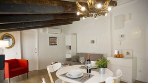 A modern dining area with a round table, white chairs, and a chandelier. - Singular Stays A. San Vicente IV (Valencia)
