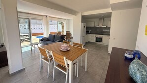 A modern living room with a dining table, sofa, and kitchen area. - Agi Las Acacias 2401 Apartamento for rent in Roses Girona. (Rosas / Roses)