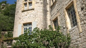 A stone tower with multiple windows and a flat-roofed building adjacent to it.