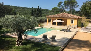 Una vila amb piscina, mobiliari d'exterior i vistes a la forest circumdant.