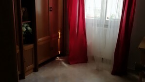 A room with a wooden wardrobe, a red curtain, and a window with sheer curtains. - MY BLACK HOMEAWAY (León)