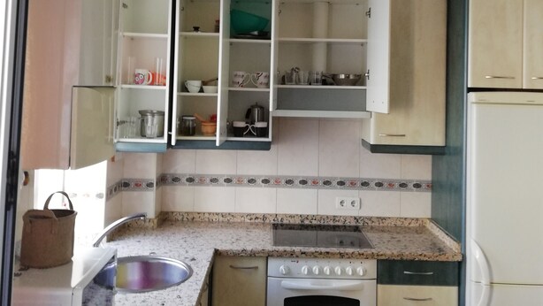 A compact kitchen with white cabinets, a built-in oven, and a sink. - MY BLACK HOMEAWAY (León)