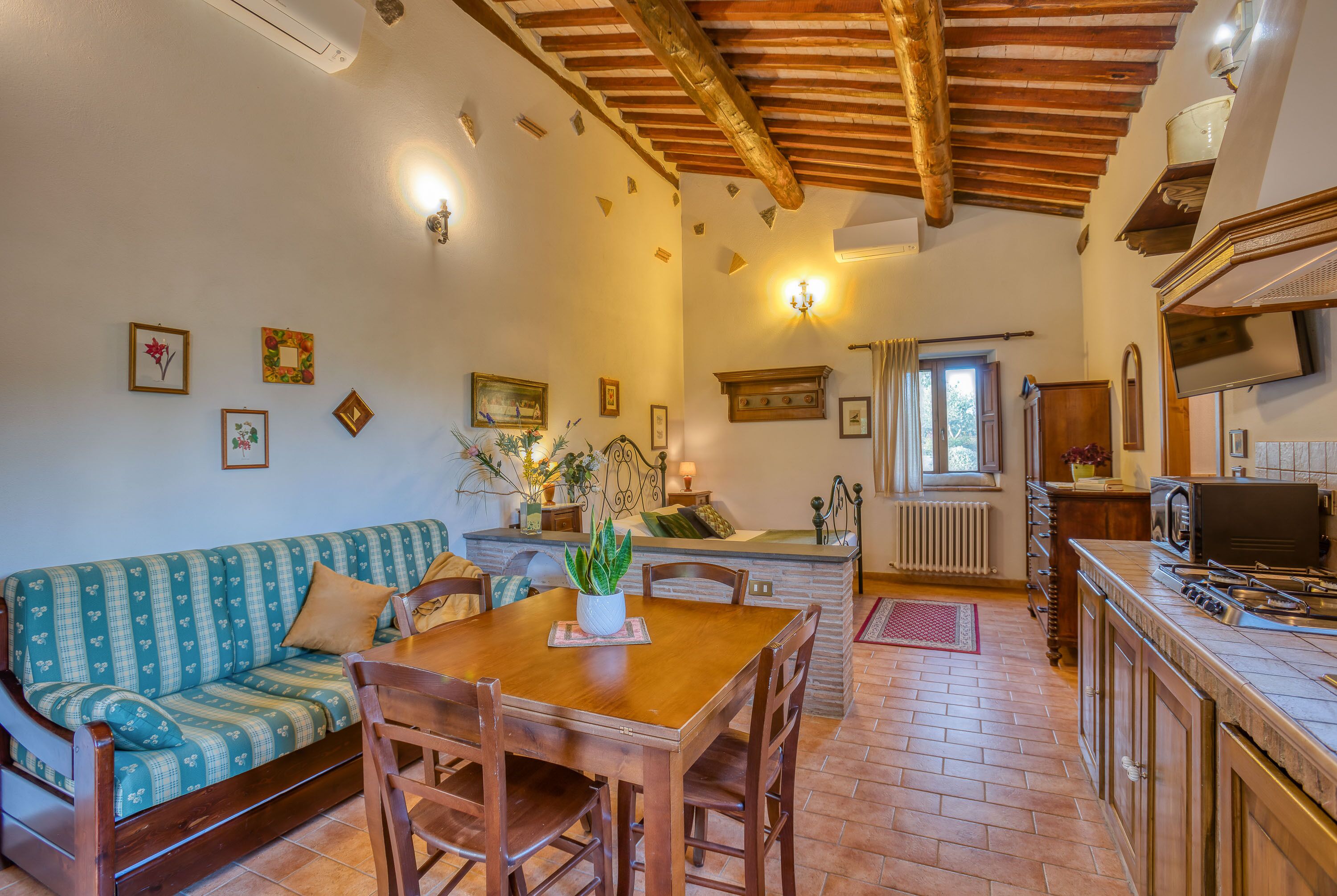 Una cocina acogedora con una mesa de madera, un sofá y una zona de comedor.