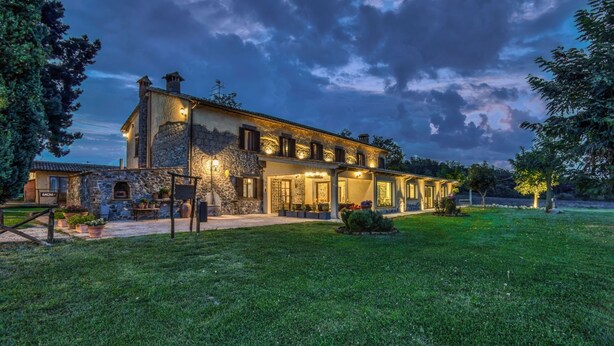 A stone building with a large patio area and a well-maintained lawn. - Agriturismo Buonasera (Bagnoregio)