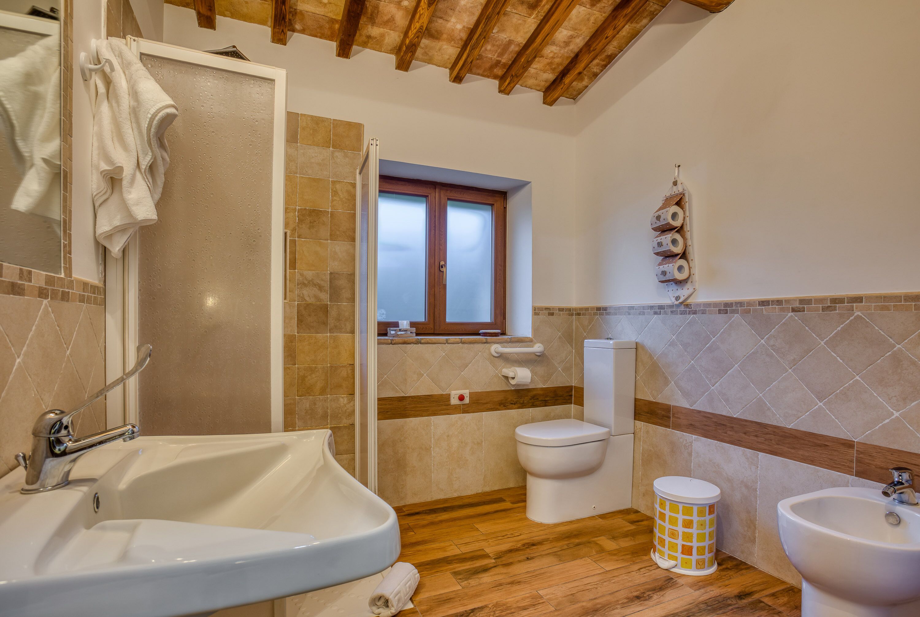 Un baño con bañera, lavabo, inodoro y ventana.