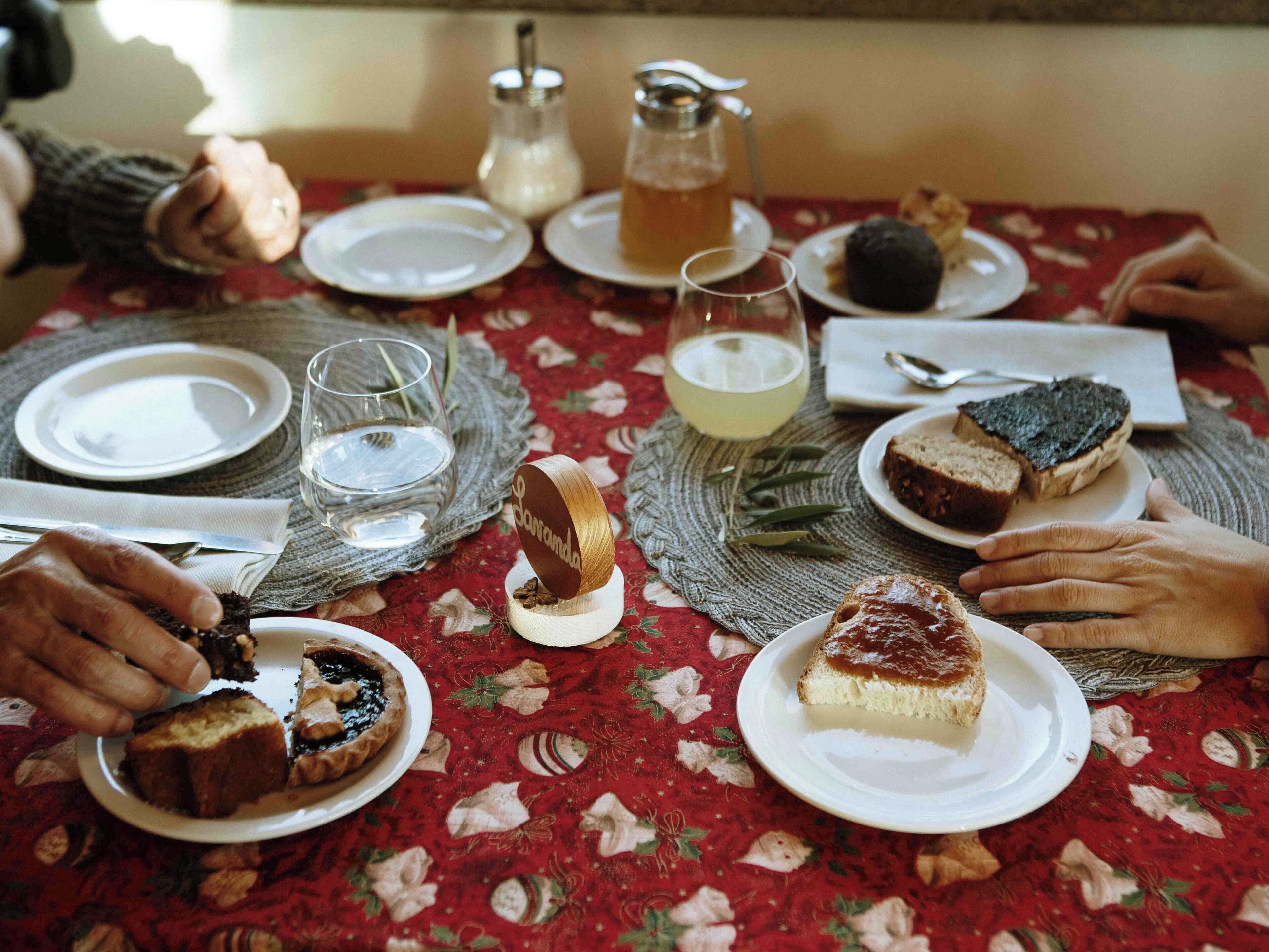 A table set with plates of food, glasses, and a pitcher.