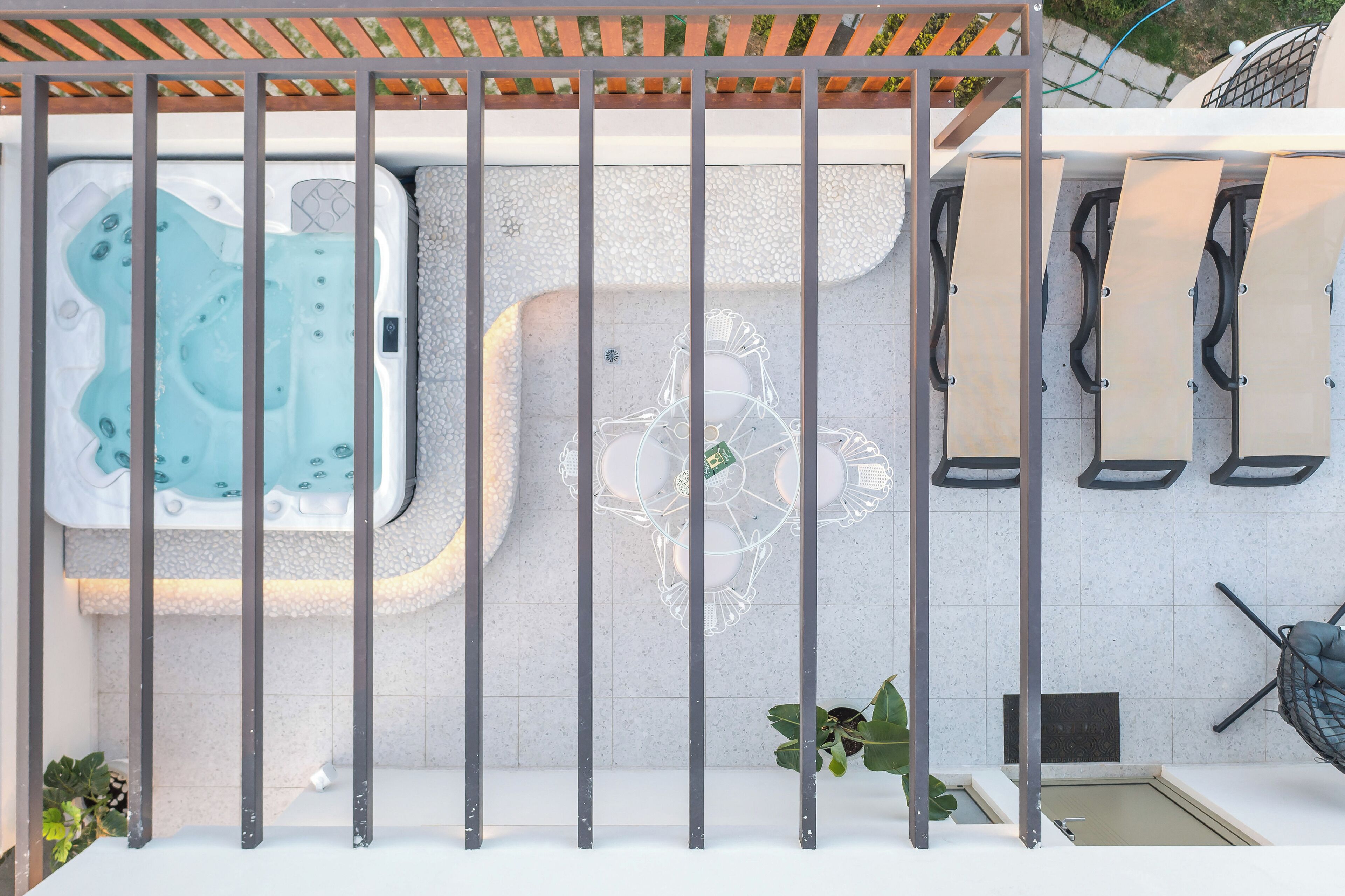 A hot tub and seating area with a pergola overhead.