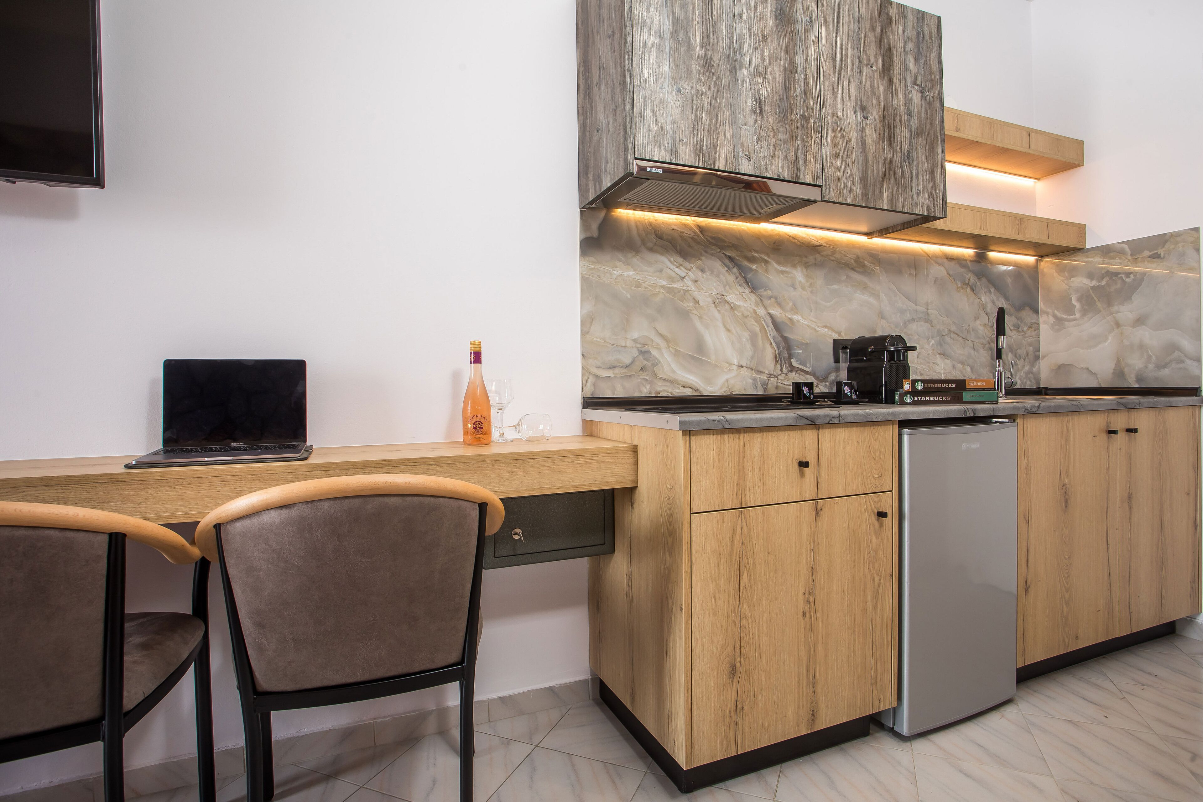 A modern kitchen with a wooden countertop, a built-in stove, and a refrigerator.