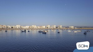 A coastal cityscape with numerous boats on calm waters, a clear sky, and a distant moon. - Carmona - T2 Holiday Apartment by São Martinho do Porto beach By SCH (São Martinho do Porto)