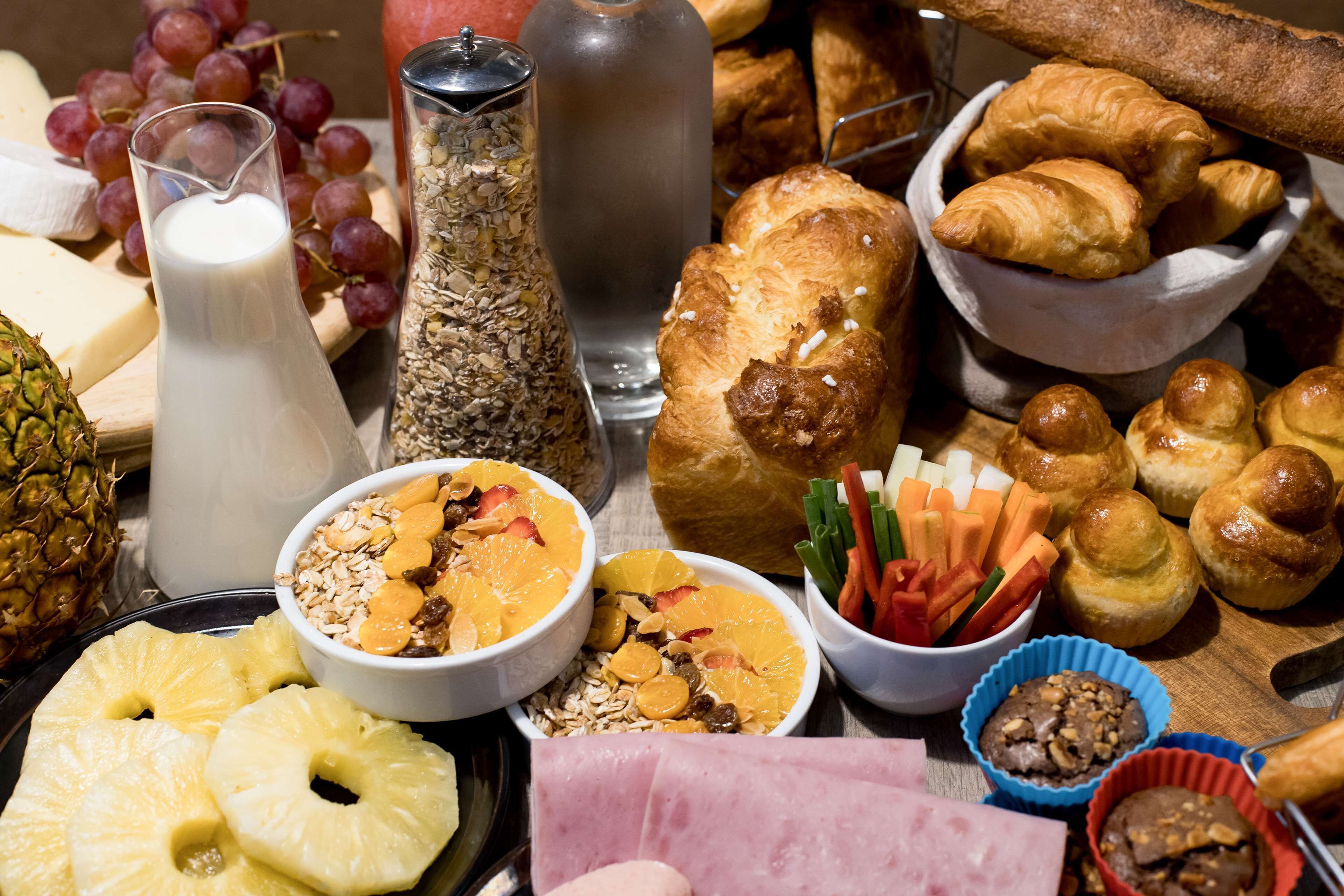 Una variedad de alimentos para el desayuno, como pasteles, frutas y bebidas.