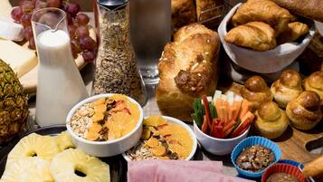Una variedad de alimentos para el desayuno, como pasteles, frutas y bebidas.