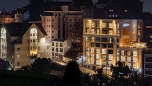 A multi-story hotel with illuminated windows and a prominent sign. - Radisson Serviced Apartments Antananarivo City Centre (Antananarivo)