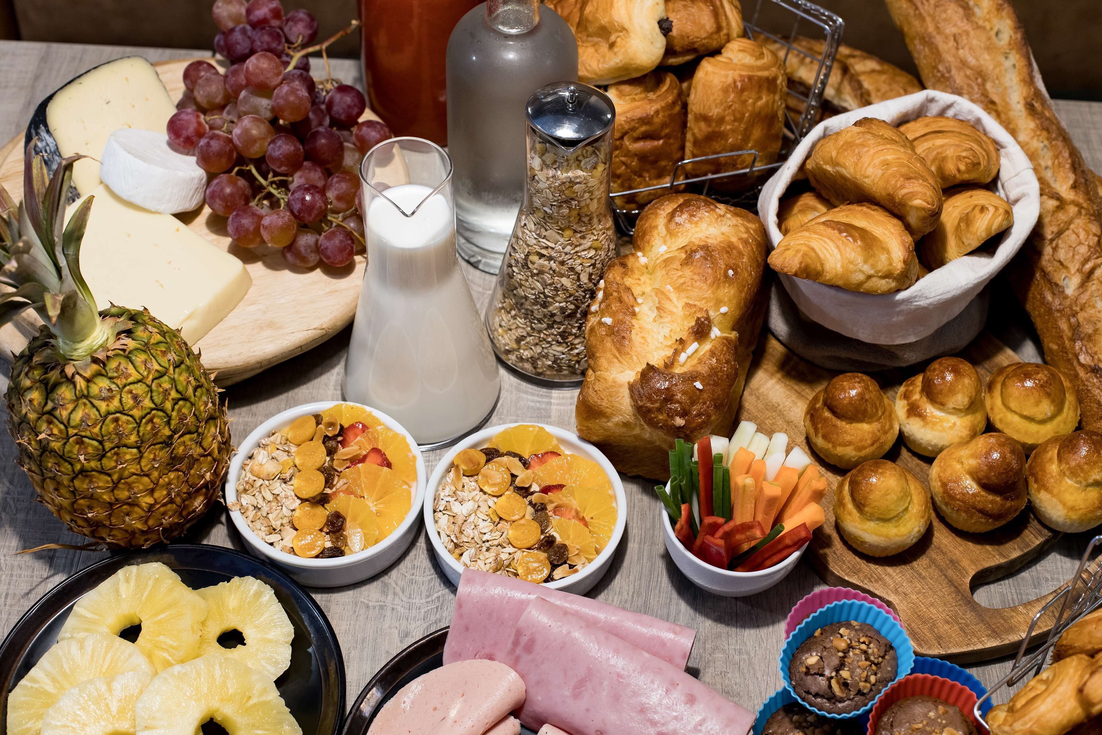 A variety of breakfast items including fruits, pastries, and dairy products.