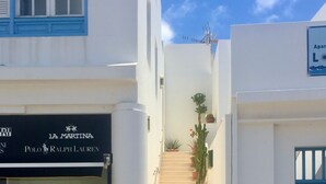 A narrow street with a shoe store on the left and a blue door on the right. - SEAHORSE-WELCOMEPLAYABLANCA (Playa Blanca)