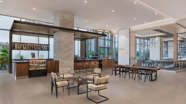 A spacious lounge area with a bar, seating, and large windows offering views of the city. - Citadines Bay City Manila (Pasay)