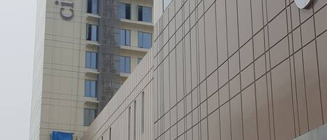Un edificio moderno con un llamativo letrero de 'Citadines', una entrada cubierta y un cartel de estacionamiento que indica una calle de un solo sentido.