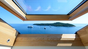A wooden deck with a clear view of the sea and boats.