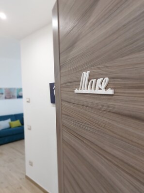 Un intérieur moderne avec un mur en bois et une enseigne blanche sur laquelle on peut lire « Mare ».