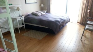 A bedroom with a bed, a desk, a chair, and a bunk bed. - Lomolen B&B (Aalter)