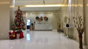 Un vestíbulo moderno con un árbol de Navidad, una recepción y decoración mural.