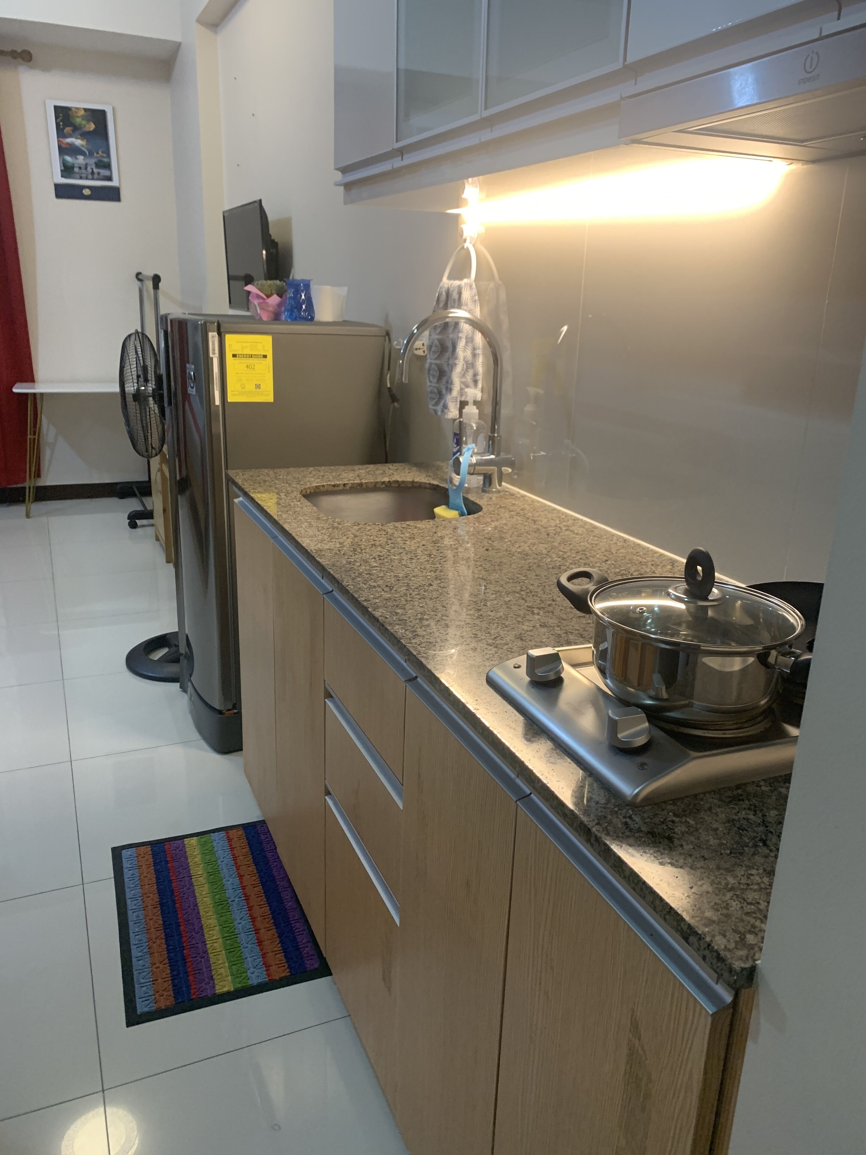 Una cocina con encimeras de granito, un refrigerador de acero inoxidable, una estufa y un microondas.