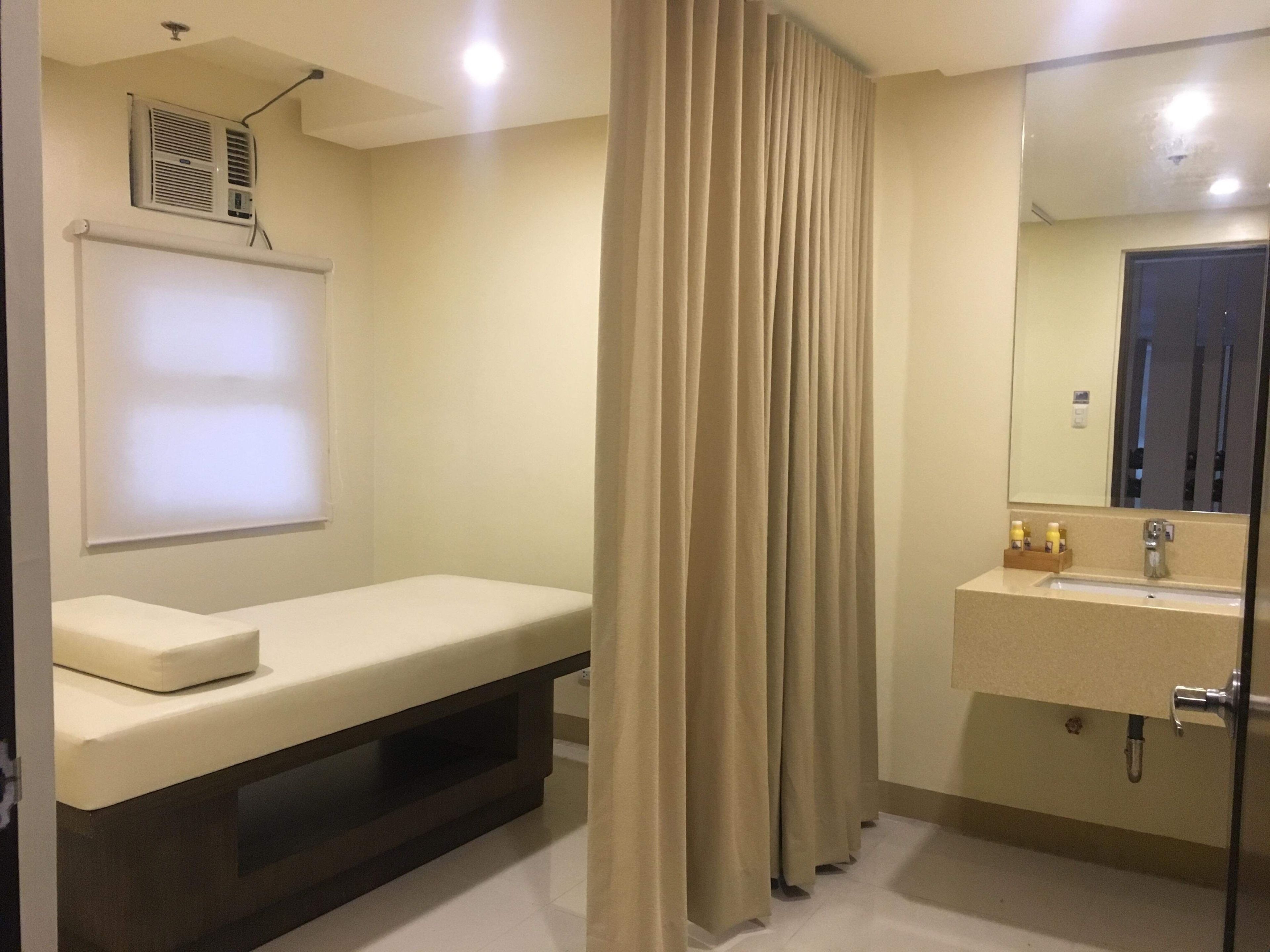 Un baño con un lavamanos blanco, un espejo, una cortina de ducha y un ventilador de techo.