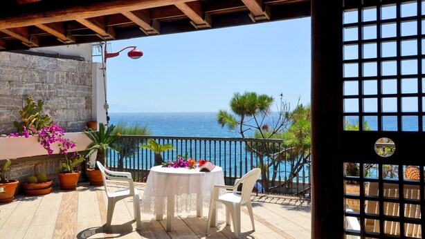 A terrace with a table and chairs, overlooking the sea. - Barabba sea house (Santa Teresa di Riva)