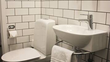 Une salle de bain avec des toilettes, un lavabo et un miroir.