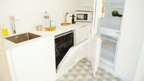Una cocina compacta con lavavajillas, microondas y refrigerador.