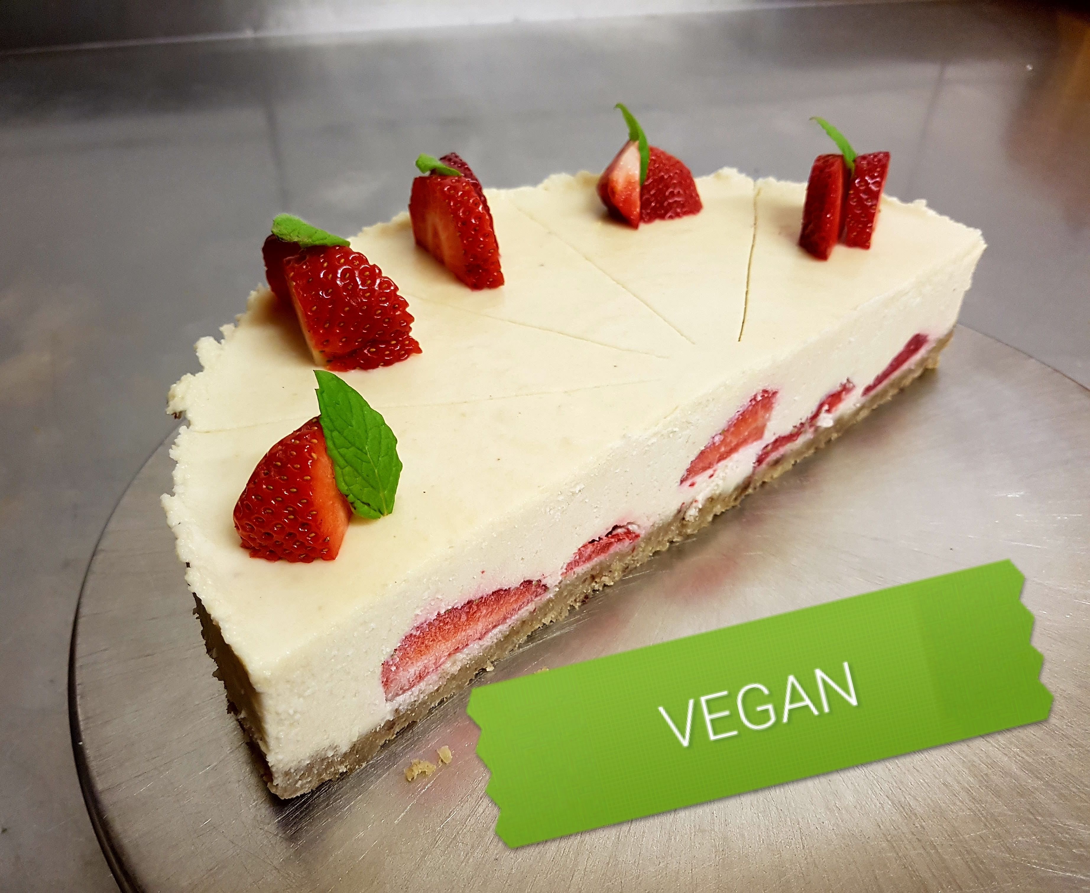 Un pastel vegano de queso con fresas por encima.