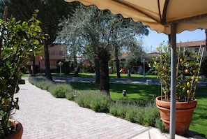 A paved pathway with a canopy, surrounded by greenery and trees. - Hotel Da Filiè (Seravezza)