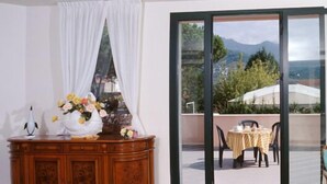 A room with a wooden cabinet, a sofa, and a table with a yellow tablecloth. - Hotel Da Filiè (Seravezza)