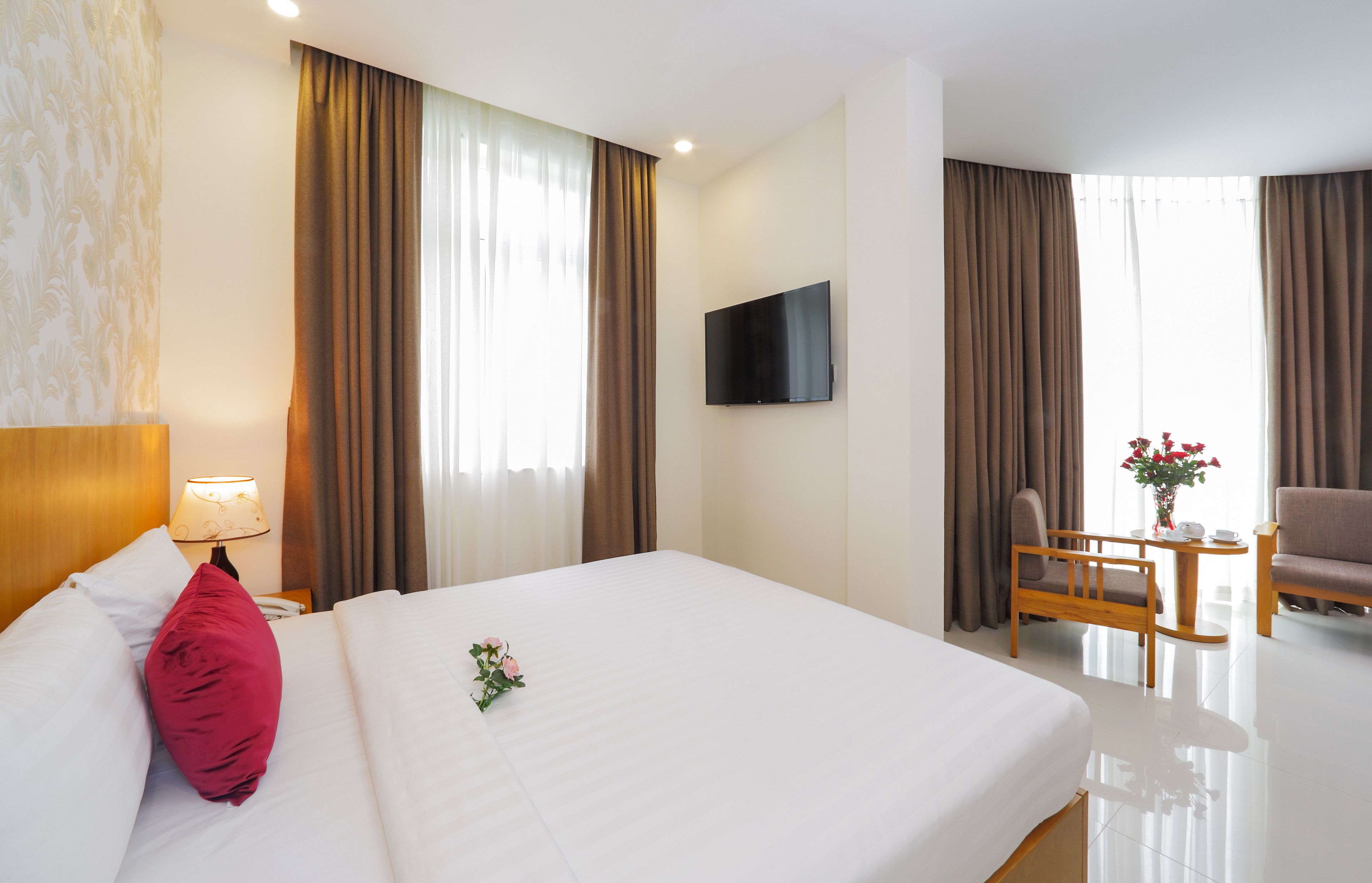 A hotel room with a bed, a TV, a desk, and a chair.