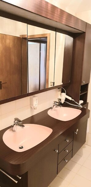 A bathroom with two sinks, a large mirror, and a towel rack. - LILTON Hotel Zuffenhausen (Stuttgart)