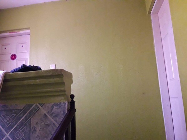 A room with a bed, a dresser, and a door.