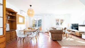 A spacious living area with a dining table, white chairs, a sofa, and a TV. - A (VA022) TH Casa Port Saplaya (Alboraya)