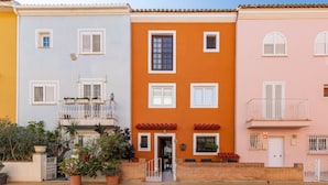 A row of colorful buildings with balconies and potted plants. - A (VA022) TH Casa Port Saplaya (Alboraya)