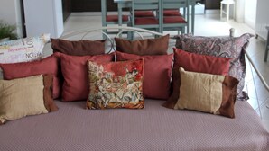 A modern living room with a sofa, a dining table, and a kitchen in the background. - Bellissima Campagna Home<br>Pelekapina Chania Crete  (Chania , Crete)