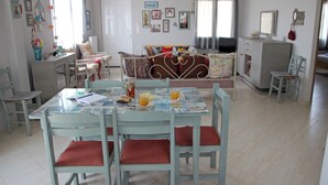 A dining area with a table set for four, surrounded by chairs with red cushions. - Bellissima Campagna Home<br>Pelekapina Chania Crete  (Chania , Crete)