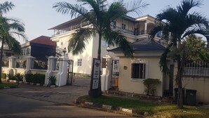 A two-story building with a gated entrance, a balcony, and a sign indicating it is a conference center. - Zeina Suites Abuja (Abuja)