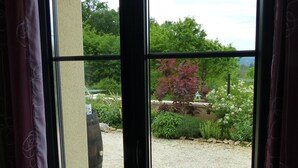 A window with a view of a garden and a building.