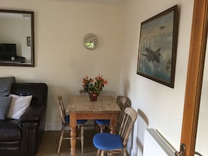 Cozy living space with a dining table, comfortable seating, and a large mirror.