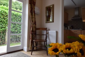 Enjoy a peaceful retreat with a garden view, a comfortable chair, and a kitchen area.