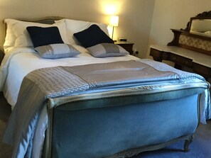 Cozy retreat with a large bed, bedside table, and dresser, perfect for a restful stay.