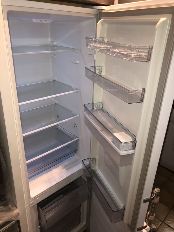 An open refrigerator with multiple shelves and a freezer compartment. - Apartment/ flat - PROPRIANO (Propriano)