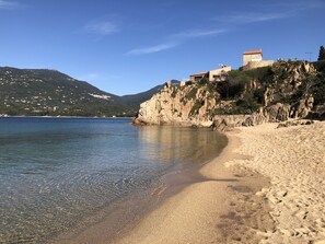 A coastal beach with clear water, sandy shore, and buildings on a rocky cliff. - Apartment/ flat - PROPRIANO (Propriano)