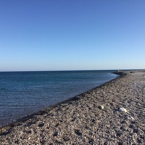Enjoy a serene beach experience with a pebble shoreline and calm sea views.