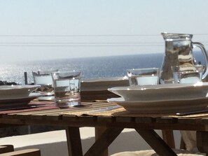 Enjoy a seaside meal at this outdoor dining table with a view of the ocean.