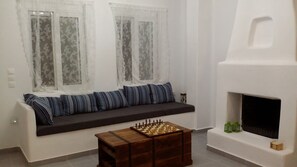Relax in this inviting living room with a comfortable sofa, wooden chess table, and fireplace.
