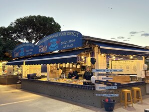 Un stand de nourriture avec une enseigne indiquant qu’il vend des « poissons corvillages » et qu’il est situé au port du Chichoulet.